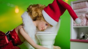 alice phoebe lou makes me vomit - a doll wearing santa hat throwing up in a toilet bowl