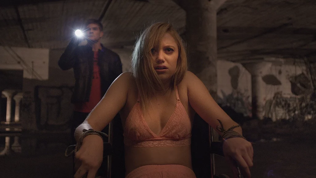 Jay dal film It Follows. Scena sedia a rotelle